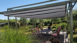 Groot terras met een grote pergola met schaduwdoek